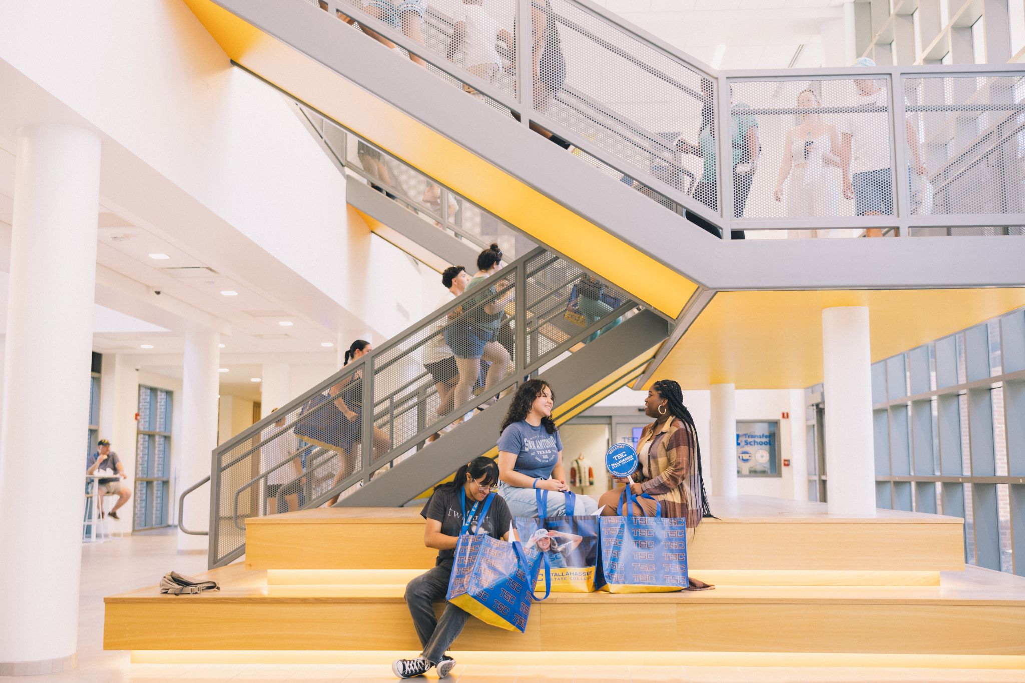 Students sitting below student union staircase.