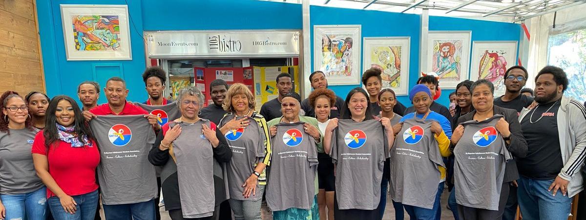 Group picture with members of the TCC and St Maarten bridge program holding up program t-shirts 