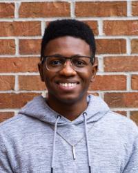 Nicholas standing in front of a brick wall